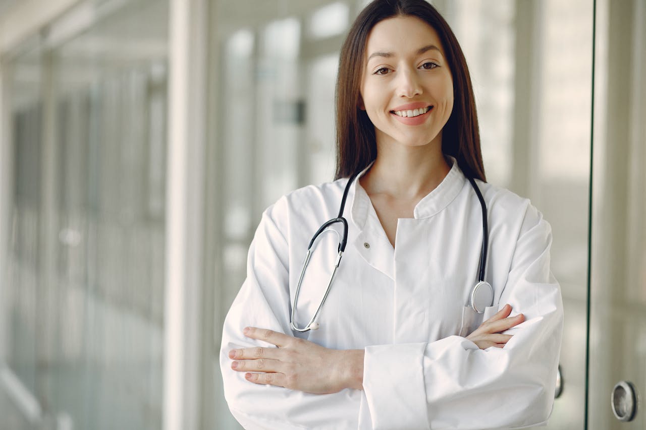 Crop doctor in medical uniform with stethoscope standing in clinic corridor 1.00