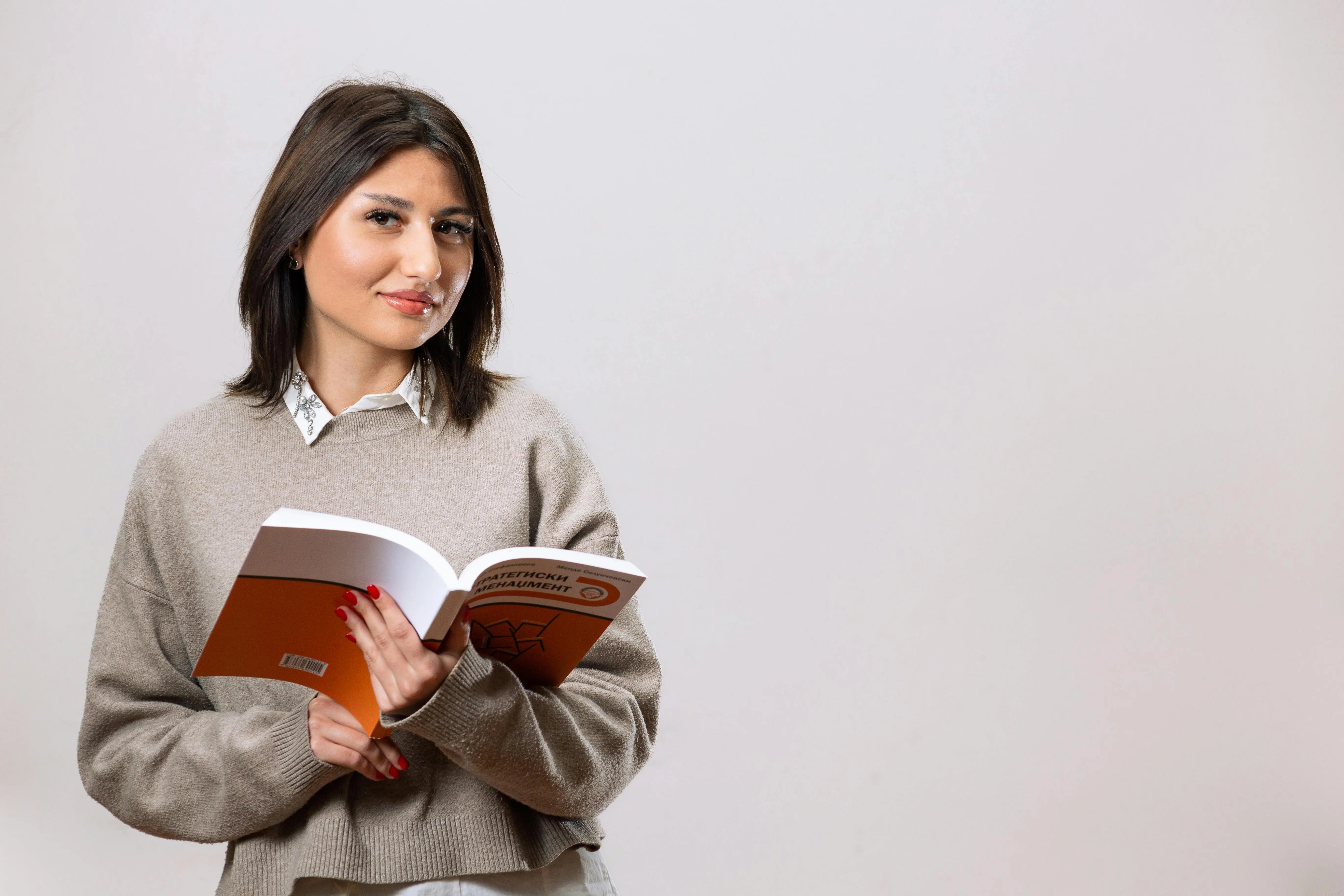 Portrait of a young woman reading a book in a studio setting, embodying a professional and stylish look. Portrait of a young woman reading a book in a studio setting, embodying a professional and stylish look.