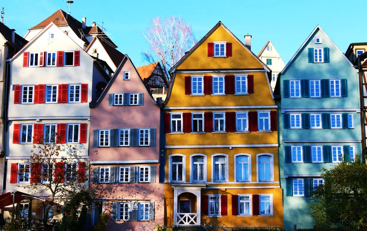 Vibrant facades of traditional houses in Tübingen&rsquo;s historic center, under a clear daytime sky.