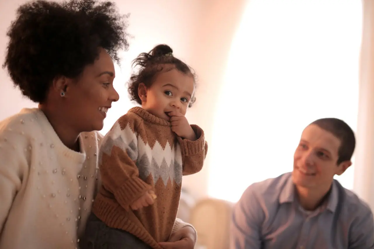 A joyful family enjoying a moment together indoors with a toddler.