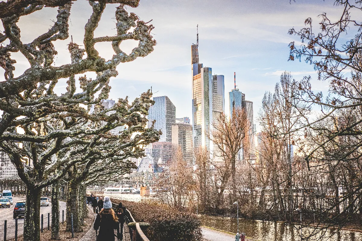 Skyline view of Frankfurt am Main with skyscrapers, river, and winter trees. Skyline view of Frankfurt am Main with skyscrapers, river, and winter trees.