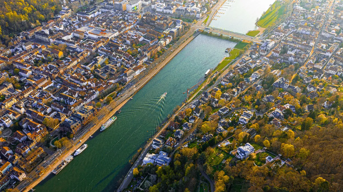 An aerial shot of a charming riverside city with boats and greenery. An aerial shot of a charming riverside city with boats and greenery.